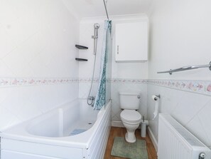 Un bagno piccolo con vasca, water e termosifone.