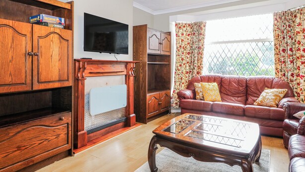 A living room with a fireplace, a television, a sofa, and a coffee table. - The Retreat (Deal)