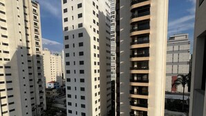 A high-rise residential building with multiple balconies and a rooftop pool. - Flat em Moema com Cozinha (São Paulo)