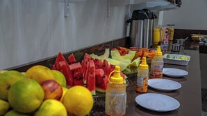 Ein reichhaltiges Buffet mit verschiedenen Früchten, Beilagen und leeren Tellern.