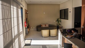 Ein modernes Wohnzimmer mit einer Couch, einem kleinen Tisch und einem an der Wand befestigten Fernseher.