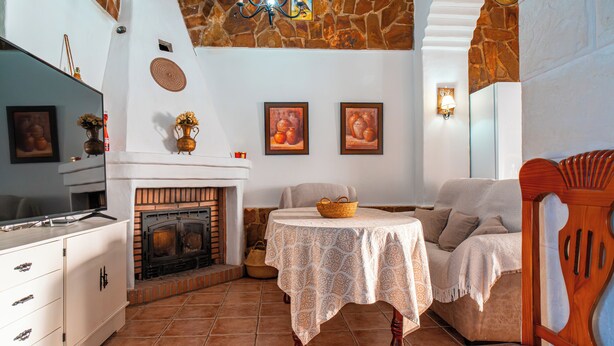 Un soggiorno accogliente con camino, televisione, tavolo da pranzo e divano.