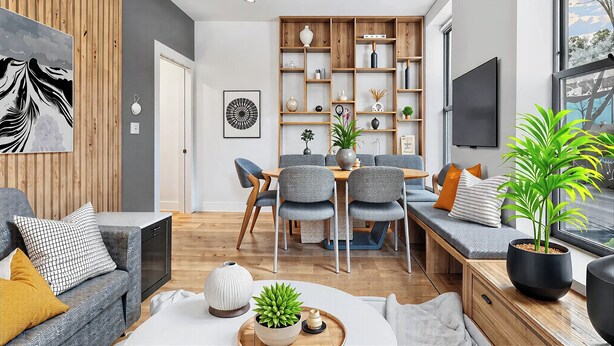 A modern living room with a dining area, wooden panel walls, a flat-screen TV, and a large window. - Two Bedroom - Newly Renovated - Washer/Dryer in New York City (New York)