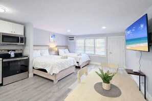 A hotel room with a kitchenette, two beds, a dining table, and a TV. - Sun-Joy Beach Stay#6, 5-Min Walk, Central Location (Myrtle Beach)