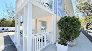 A two-story house with a white porch, a potted plant, and a clear sky. - Sun-Joy Suite #7 | Walk to Ocean, Myrtle Beach (Myrtle Beach)