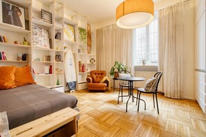 Une pièce confortable avec un lit, une chaise, une table et une bibliothèque.