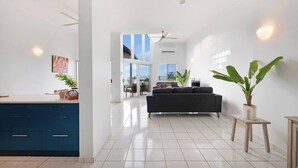A modern living room with a sofa, a coffee table, and a potted plant.