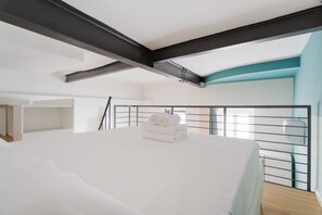 Ein modernes Schlafzimmer mit einem großen Bett, einem Balkon mit Geländer und Blick auf die Stadt.