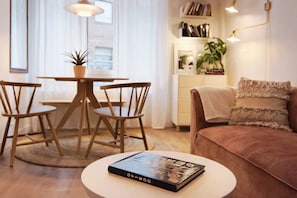 A cozy living room with a round coffee table, a sofa, and a dining area with chairs and a table. - R2R -Apartment in downtown Oviedo - 660A (Oviedo)