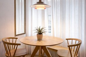 A round wooden table with two chairs, a potted plant, and a pendant light. - R2R -Apartment in downtown Oviedo - 660A (Oviedo)