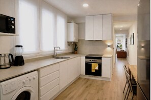 A modern kitchen with a washing machine, a coffee maker, a stove, and a sink. - R2R -Apartment in downtown Oviedo - 660A (Oviedo)