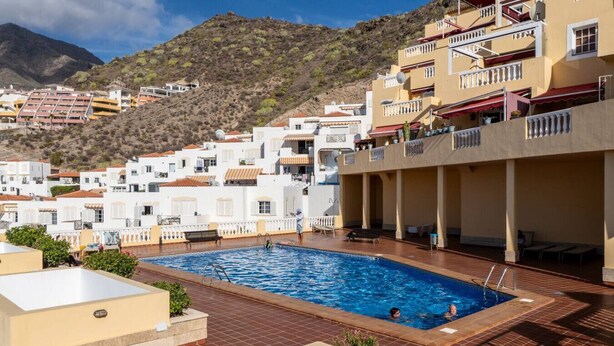 Une piscine avec vue sur une ville située sur une colline.