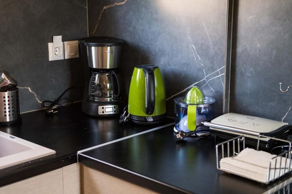 A kitchen counter with a coffee maker, a juicer, and a small appliance.