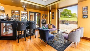 A modern interior with a bar area, seating, and a view of the outdoors.
