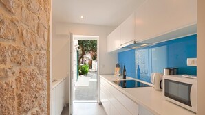 A modern kitchen with white cabinets, a blue backsplash, and a microwave. - Villa Antea - Five Bedroom Villa, Sleeps 12 (Bol)