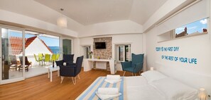 Une chambre moderne comprenant un lit, un bureau et un coin salon avec des fauteuils.