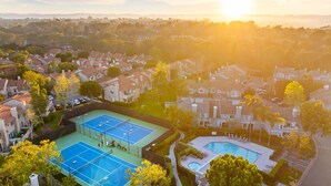 Zona residencial amb cases, una pista de tennis i una piscina.