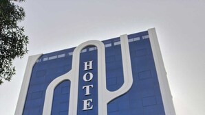 Un edifici d'hotel modern amb un senyalitzador important que diu 'HOTEL' a la façana.