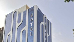Un hotel modern amb un disseny arquitectònic distintiu, amb finestres grans i un cartell prominent que diu 'HOTEL'.