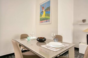 A dining table set with plates, glasses, and a bowl, with a framed picture above. - Italianway - Pontetto 8 (Santa Margherita Ligure)