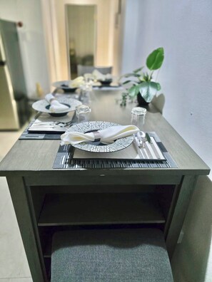 A dining table set with plates, cutlery, and napkins, with a plant and a glass on the table. - Cozy 2 Bedroom Flat W Pool/ Free Parking (Philipsburg)