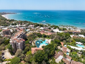An aerial view of a coastal resort with a central swimming pool, beachfront villas, and a beach. - Two bedroom  in Costa Rica, Tamarindo (Tamarindo)