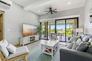 A spacious living area with a flat-screen TV, a ceiling fan, and a large sliding glass door leading to a patio with outdoor furniture. - Two bedroom  in Costa Rica, Tamarindo (Tamarindo)