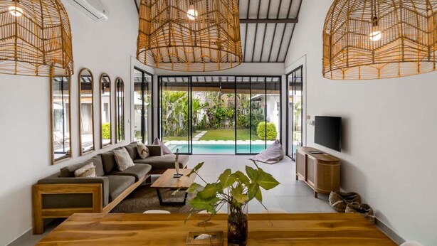 Ein modernes Wohnzimmer mit einem Holzespeisetisch, einer Couch und einem großen Fenster mit Blick auf einen Pool.