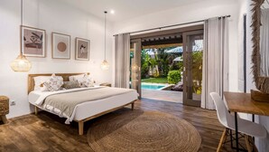 Ein Schlafzimmer mit Bett, Schreibtisch und Blick auf einen Swimmingpool.