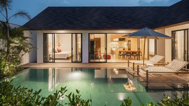 Ein modernes Haus mit Swimmingpool, Essbereich und einer Lounge mit Sesseln.