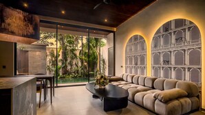 Un salon moderne comprenant un canapé, une table basse et un coin repas avec des chaises.