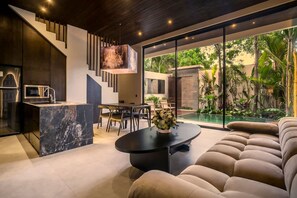 Ein modernes Interieur mit einer Küche, einem Essbereich und einem großen Fenster mit Blick auf einen Garten.