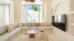 Een moderne woonkamer met een modulaire bank, een salontafel en een flatscreen televisie.