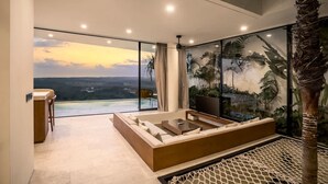 Una sala de estar moderna con un ventanal grande, un sofá, un televisor y una planta decorativa.