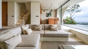 Una sala de estar moderna con un sofá, un comedor y una escalera.