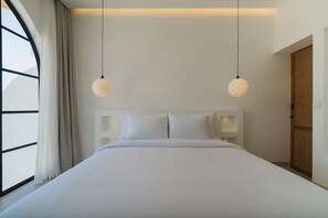 Une chambre moderne avec un grand lit, deux lampes suspendues, une fenêtre avec des rideaux et une armoire en bois.