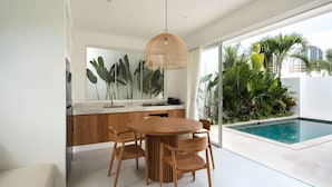 Una cocina moderna con comedor, ventanas amplias y piscina.
