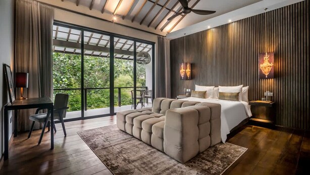 Un dormitorio moderno con una cama grande, un espacio para sentarse y un escritorio.