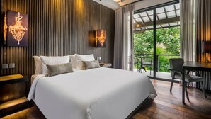 A modern bedroom with a large bed, a desk, and a balcony with a view. - Umayam Luxury Townhouse 7 (Pererenan)