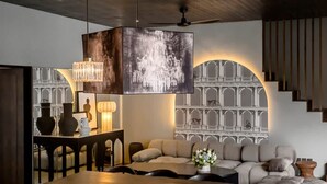 A modern interior with a dining area, sofa, staircase, and decorative wall. - Umayam Luxury Townhouse 7 (Pererenan)