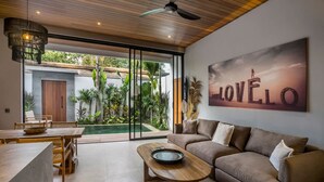 Ein modernes Wohnzimmer mit Sofa, Couchtisch und Essbereich.