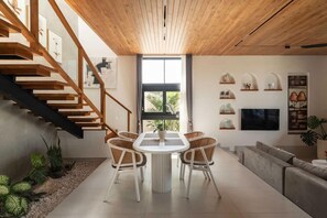 A modern interior with a staircase, dining area, and living space. - Ben s Villa 2 in Kuta Utara (Kuta Utara)