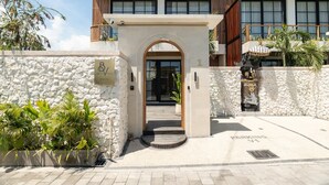Ingresso di un hotel con facciata in pietra, un arco e un'indicazione di parcheggio.