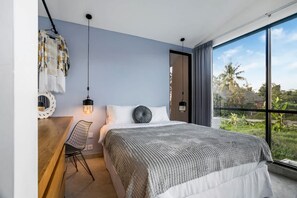 Ein modernes Schlafzimmer mit einem großen Bett, einem Hängesessel und Blick auf Grün.