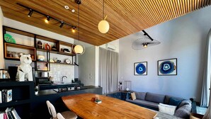 Una cocina moderna con comedor, sofá y estantería.