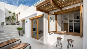Une cuisine moderne agrémentée d’éléments en bois, un coin bar avec des tabourets et un escalier menant à une chambre.