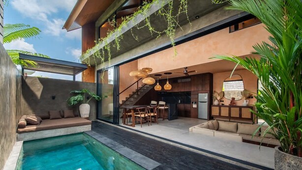 A modern house with a swimming pool, outdoor seating, and a staircase leading to an upper level. - The Mystik Loft Nirvana (Pererenan)