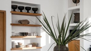Una cucina moderna con scaffali in legno, un'isola centrale e sgabelli da bar.