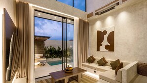 Un salon moderne avec vue sur la piscine, un ensemble de canapés et une table à manger.