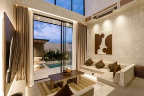 A modern living room with a pool view, a sofa set, and a dining table. - Villa Fresko 4 in Mengwi (Mengwi)